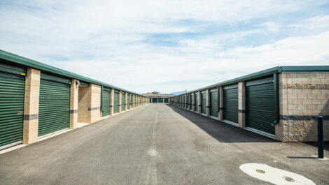 Row of green outdoor storage units at the Towne Storage Colt Plaza Storage Facility